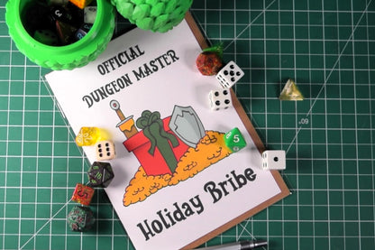 The 'Official Dungeon Master Holiday Bribe' greeting card laid out on a crafting table, prominently displaying the front artwork with an assortment of gaming dice scattered around it, creating a thematic gaming environment.